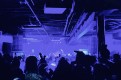 Monotronic performing live under blue stage lights in front of a crowded venue